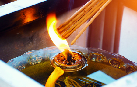 incense stick burning by candleの写真素材