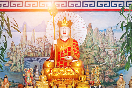 Monk Xuanzang statue in full gold suite and mace on hand at local chinese temple in Chiang Mai Thailandのeditorial素材
