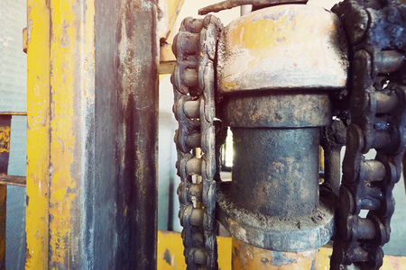 old vintage photography effect of mechanical equipment part with cogwheel and chain in dirty and rustyの写真素材
