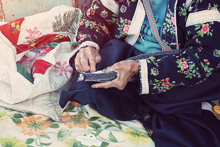 local old female Hmong Mountain Tribal sewing cloth by hand for sell at Doi Ang Khang, Chiang Mai, Thailandの写真素材