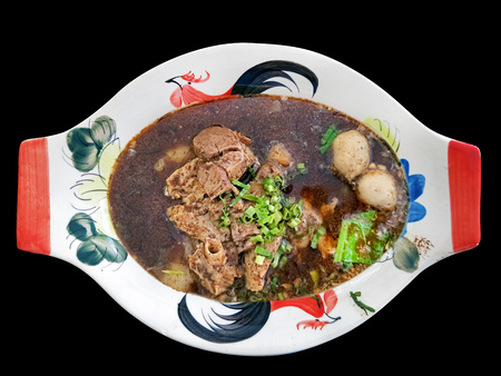 local thai noodle with herbal and pork blood thick soup called Kuay Teow Rua served in common thai style bowl isolated on black backgroundの写真素材