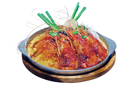 isolated on white background Thai Traditional Local Food - Pad Thai is stir fried rice noodles in tamarind chiili sauce with big shrimp served on iron fire hot plateの写真素材