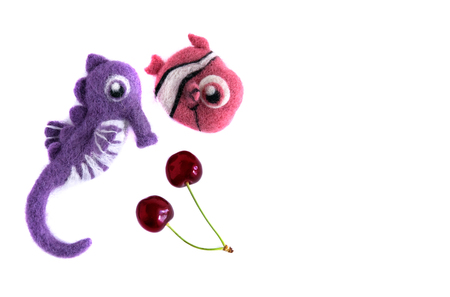Pink fish and purple sea horse handmade wool and cherries Isolate on white backgroundの写真素材