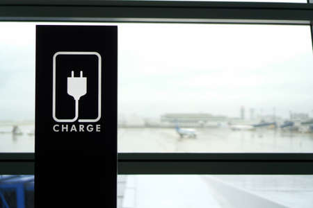 Rest area with CHARGE sign with Airport view though windowの写真素材