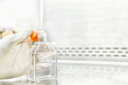 The women researcher using pipette and cell culture flask do the aseptic technique for changing the medium of adherent cell culture is needed to maintain cells in numeral growth.の写真素材