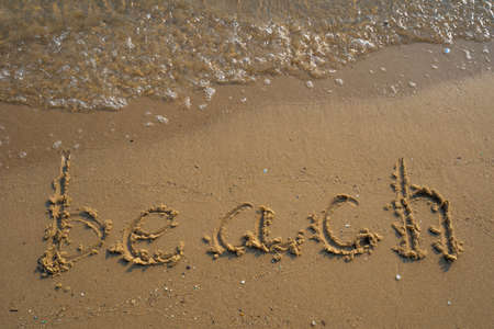 Vacation on the sand beach concept. Beach words written into the sand on the beach at Rayong, Thailand.の写真素材