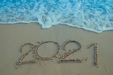 Happy New Year 2021 concept, 2021 number lettering on the sea beach, wave and golden light of...