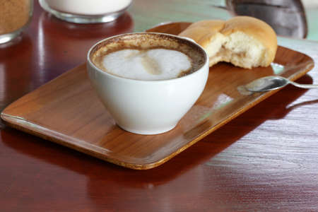 Seattle's favorite drink, Coffee! Coffee with a crosaunt on a brown wood countertop, the typical Seattle Breakfast.の写真素材