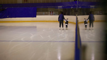 Children play ice hockey on the ice rink. Children learn to skate.