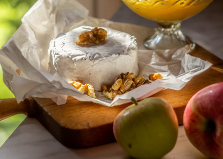 The brie cheese. Tasty camembert and walnuts, honey in a bowl, apples next to it. Closeup view, selective focusの写真素材