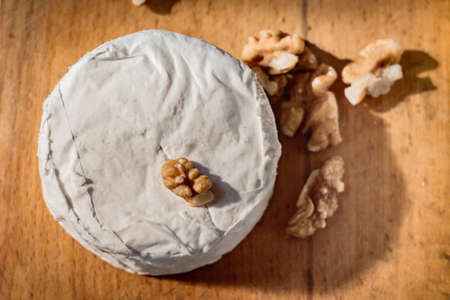 Brie cheese or camembert on cheese platter with walnuts. Closeup view, selective focusの写真素材
