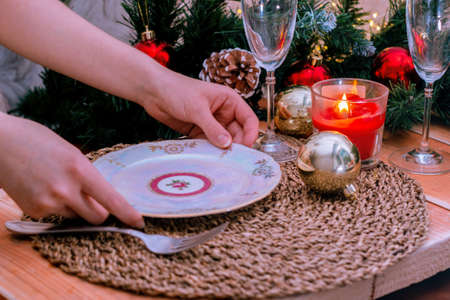 TheThe woman hands sets the table, serves dinner. Christmas dinner, a festive dish, close-up. Selective focusの写真素材