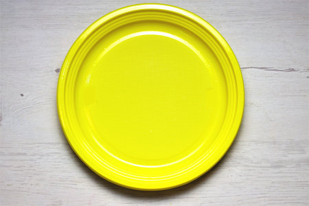 Round yellow plate on wooden board