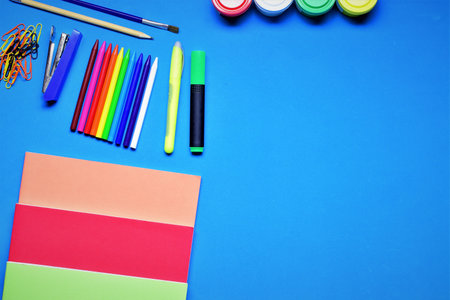 Assorted school supplies, on blue background