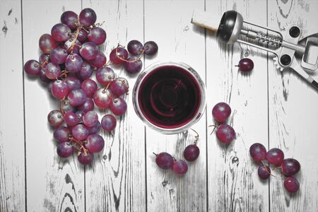 Glass of wine, outline with grapes, large bunch and corkscrewの写真素材