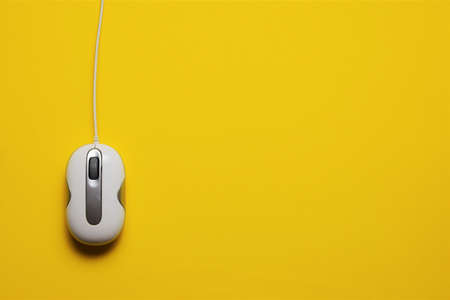 Wired pc mouse on yellow background, space for textの写真素材