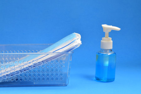 Aerial view blue background, surgical masks and hand gel, space for text