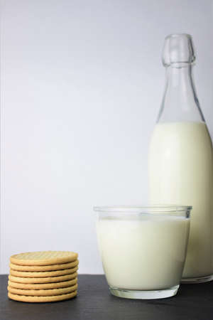 Close-up a glass of milk as main shot along with cookies on slate tableの写真素材
