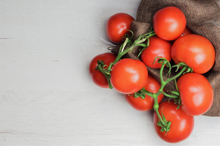 Red tomato branches on wooden table, space for textの写真素材