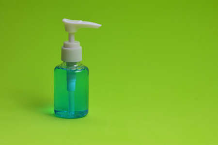 Close up, disinfecting hand gel on green background, space for textの写真素材
