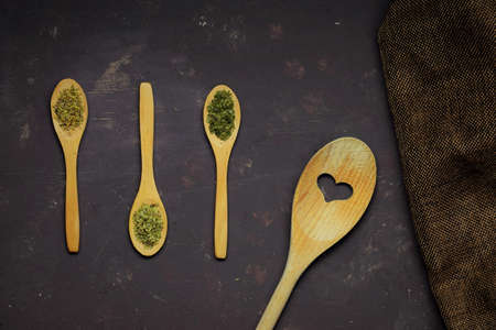 Wooden spoons, three of them small with spices, all on rustic tableの写真素材