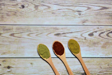 Three small spoons with spices on wooden boards, space for textの写真素材