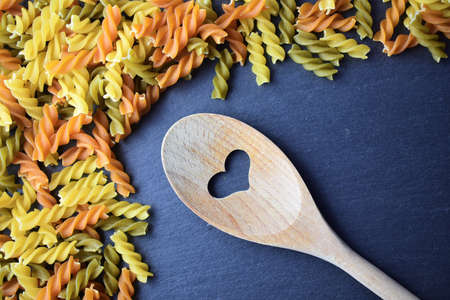 Wooden spoon on slate, with colored paste, in this case spiralsの写真素材