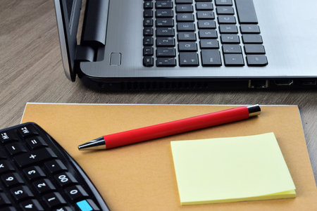 Workplace, computing and technology, laptop and mobile. Notepad and red pen