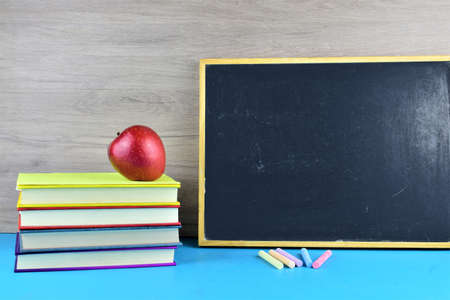 School outline, backpack with daily supplies, blackboard and textbooks, on top of them a red appleの写真素材