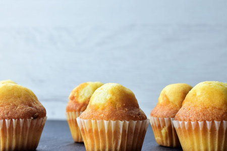 Close up in the center. Homemade mini muffins on slate table, space for text