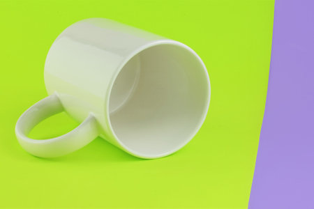 White porcelain mug as close-up, on two-color background. Space for text.
