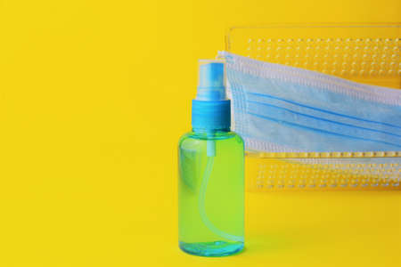 Close up, hygienic measures, hydroalcoholic gel and surgical masks, on a yellow backgroundの写真素材