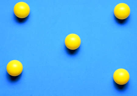 Group of yellow balls in line, on blue backgroundの写真素材