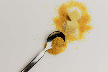 Metal spoon, outline scattered into small granules and sugar cubes, space for textの写真素材