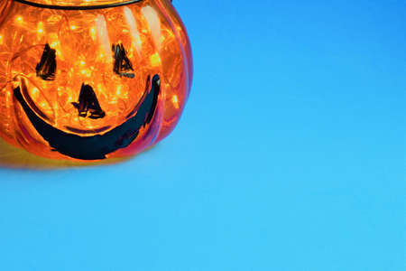 Halloween holiday, glass decoration with small interior lights on blue backgroundの写真素材