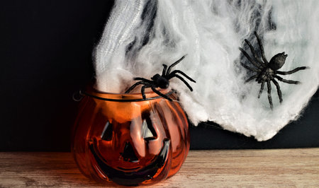 Scary background, panic spiders around, cobwebs and halloween pumpkin, representing the famous...