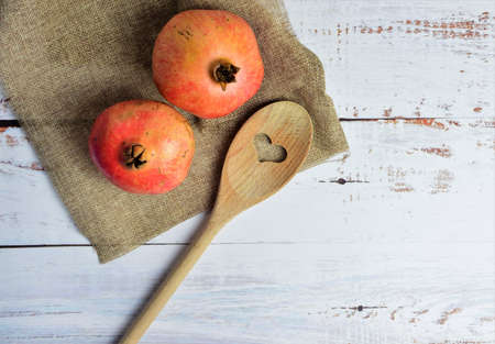 Pomegranates on cloth with a rustic touch, white boards and space for text or ideaの写真素材
