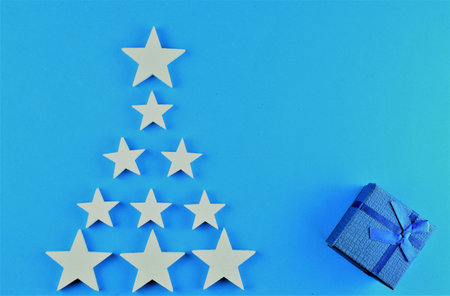 Blue background with white stars and gift. Representation to Christmas.