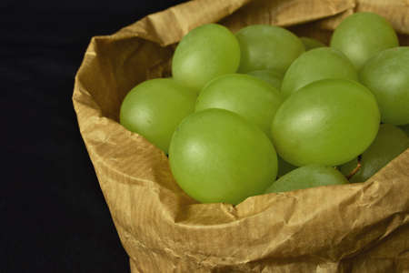 Bunch of grapes, close up. Inner kraft paper bag. Ecological. The grapes are also used to take on New Year's Eve, the well-known twelve grapes, in several Latin American countries and also in Spain.の写真素材