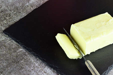 Block of butter, on slate boardの写真素材