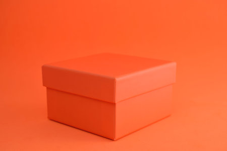 Orange cardboard box with a background of the same color.