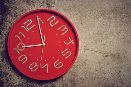 Red clock with large numbers, on stone background. Copy space.の写真素材