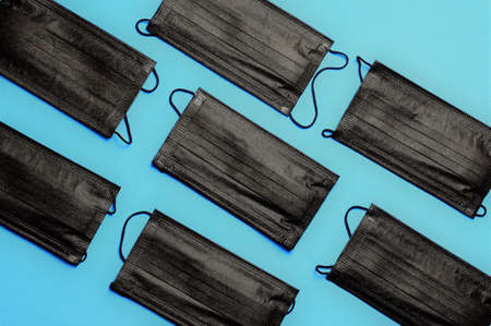 Black surgical masks on blue background.の写真素材
