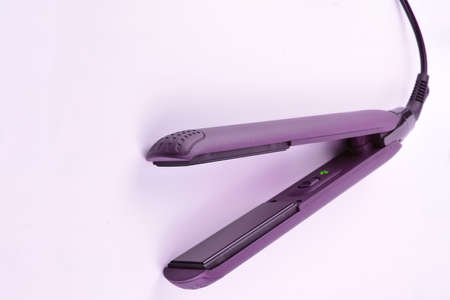 Hair straightener with ceramic plates isolated on light background.の写真素材