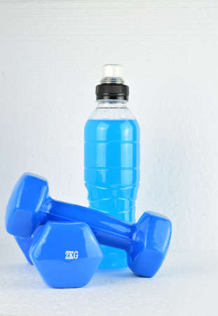 White background, dumbbells and isotonic drink, copy space.の写真素材