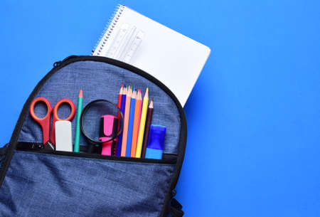 School, backpack varied school supplies. Blue background base and copy space.の写真素材