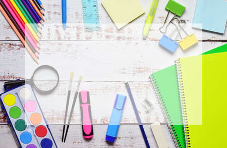 Variety of school supplies on light colored rustic wood. Back to school. Copy space in central area with transparency.の写真素材