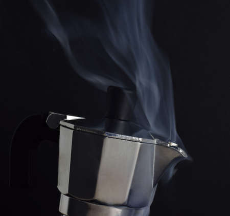Aluminum coffee pot, hot, ready to serve coffee, black background. Copy space.の写真素材