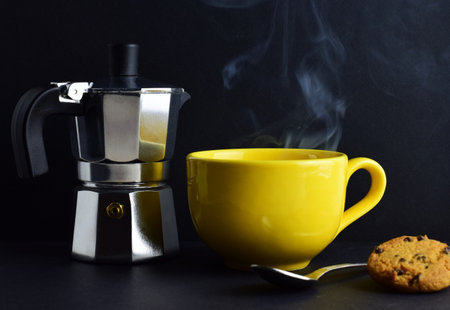 Yellow, hot mug, rising smoke, coffee pot in outline, black background and copy space.の写真素材