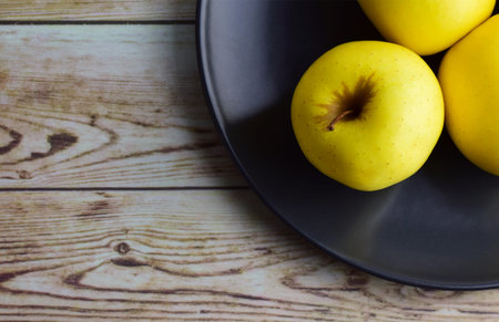 Zenith view. Group, yellow apples on old woods and plate, copy space.の写真素材
